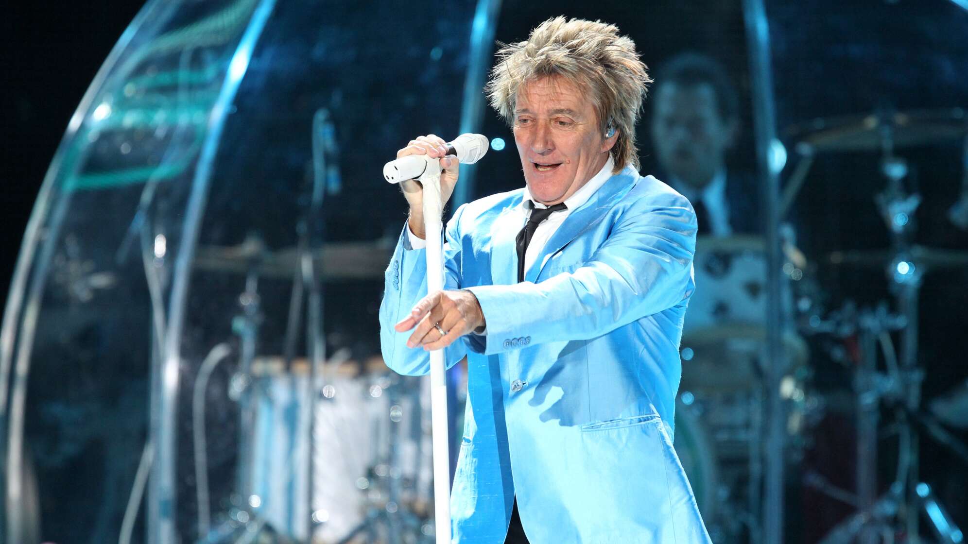 Rod Stewart in blauer Jacke auf der Bühne